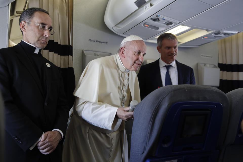 Pope Francis is flanked by his spokesperson Matteo Bruni, right, and Pope's trip organizer father Mauricio Rueda as he addresses journalists during his flight from Antamanarivo to Rome, Tuesday, Sept. 10, 2019, after his seven-day pastoral trip to Mozambique, Madagascar, and Mauritius. (AP Photo/Alessandra Tarantino)