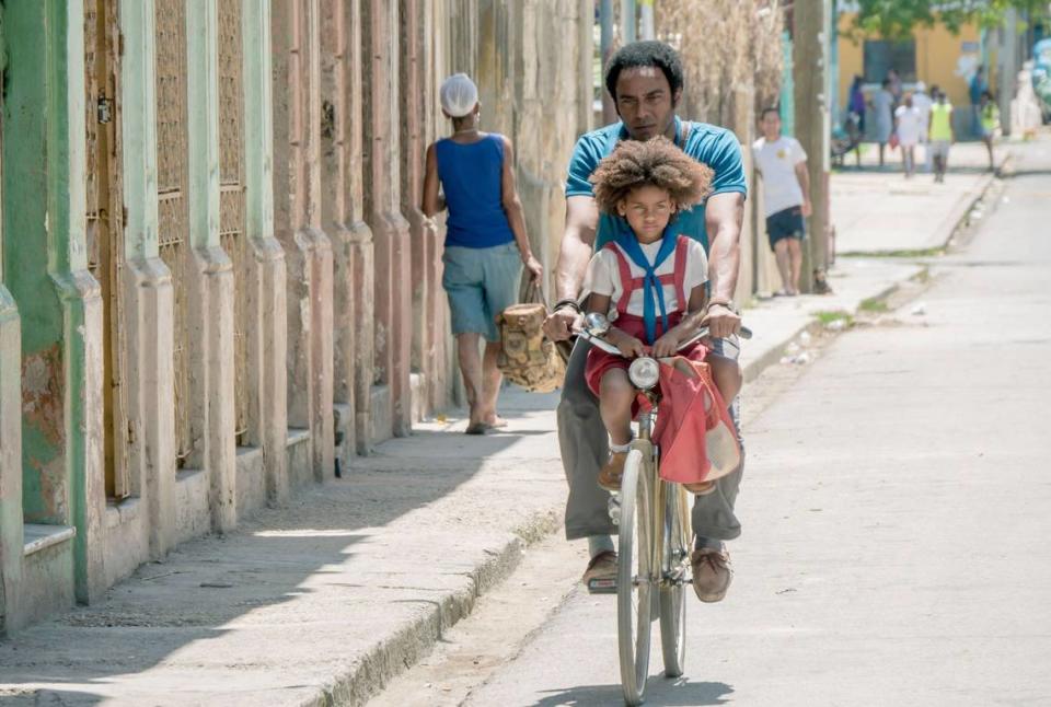 Father and daughter riding a bike in a scene from the Cuban film “Sergio and Sergei.”