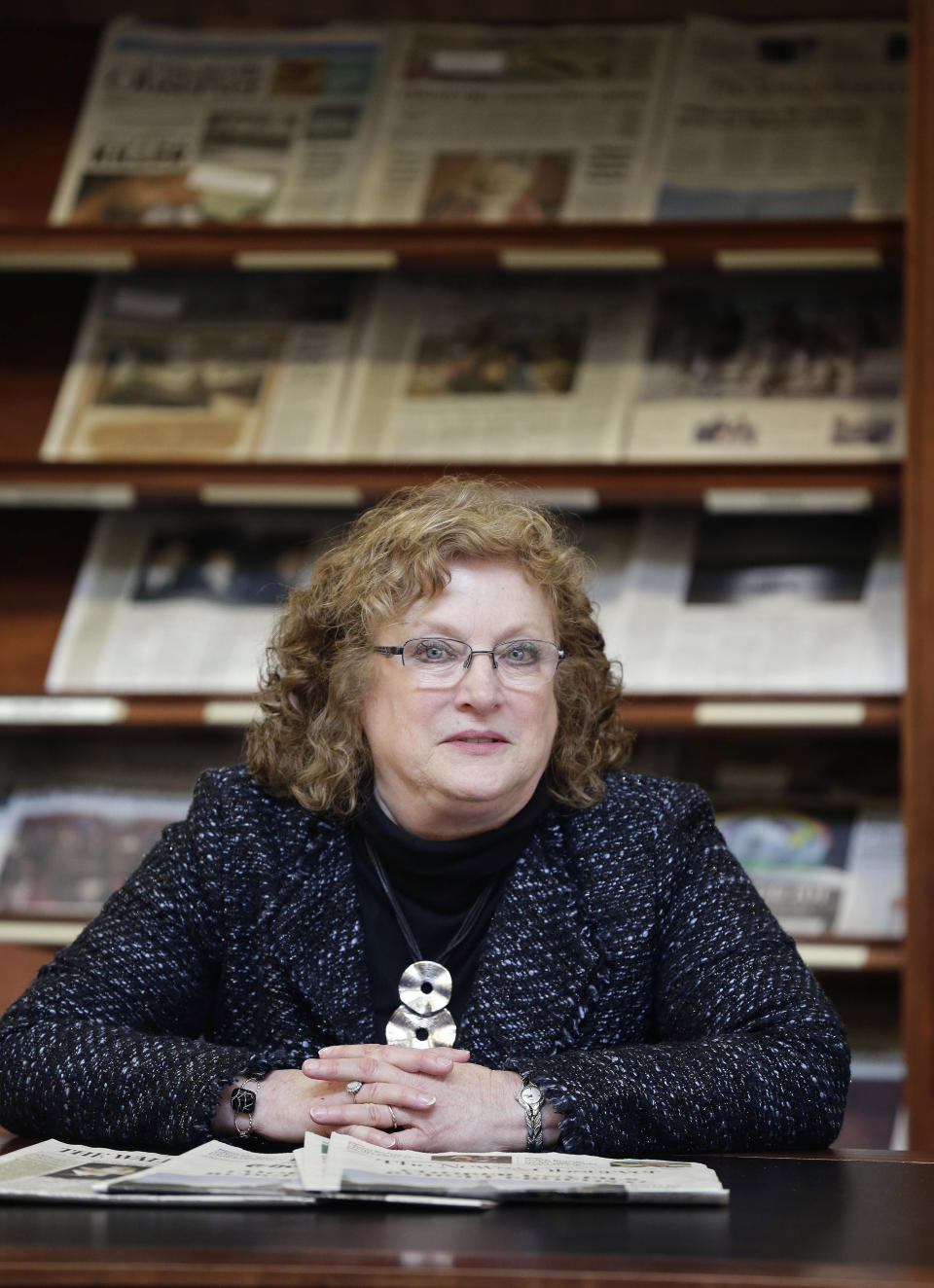 Penelope Muse Abernathy, a University of North Carolina professor, stands with the daily newspaper selection in the Park Library at the School of Journalism in Chapel Hill, N.C., on Thursday, March 7, 2019. "Strong newspapers have been good for democracy, and both educators and informers of a citizenry and its governing officials. They have been problem-solvers," said Abernathy, who studies news industry trends and oversaw the "news desert" report released the previous fall. (AP Photo/Gerry Broome)