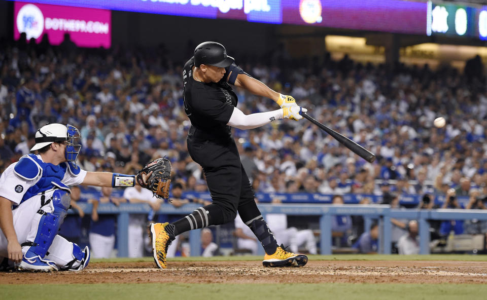 New York Yankees' Aaron Judge hits a solo home run next to Los Angeles Dodgers catcher Will Smith during the third inning of a baseball game Friday, Aug. 23, 2019, in Los Angeles. (AP Photo/Mark J. Terrill)