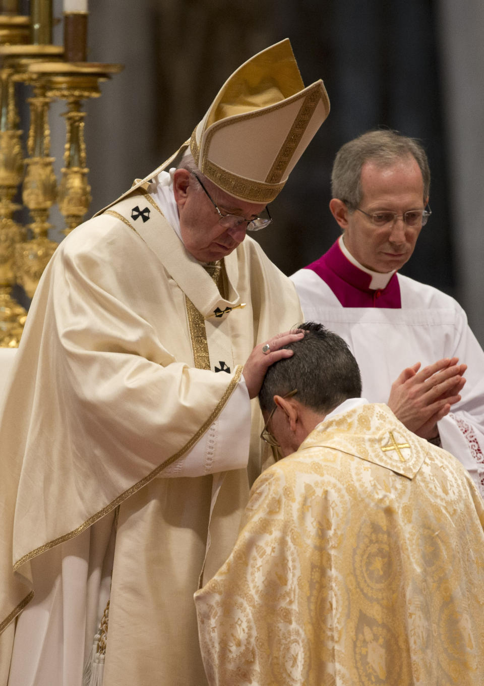 FILE - In this March 19, 2016 file photo Pope Francis poses his hands on the head of Father Miguel Angel Ayuso Guixot, during a Mass for the ordination of new bishops, in St. Peter's Basilica at the Vatican. Bishop Guixot is among 13 men Pope Francis admires, resembles and has chosen to honor as the 13 newest cardinals who will be elevated at a formal ceremony on Saturday, Oct. 5, 2019. (AP Photo/Alessandra Tarantino, file)