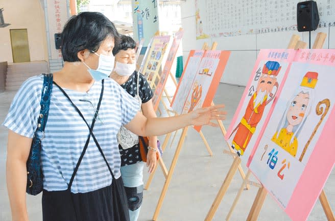 屏東縣潭頭社區居民透過學生畫作，串連兩代間信仰的價值。（林和生攝）