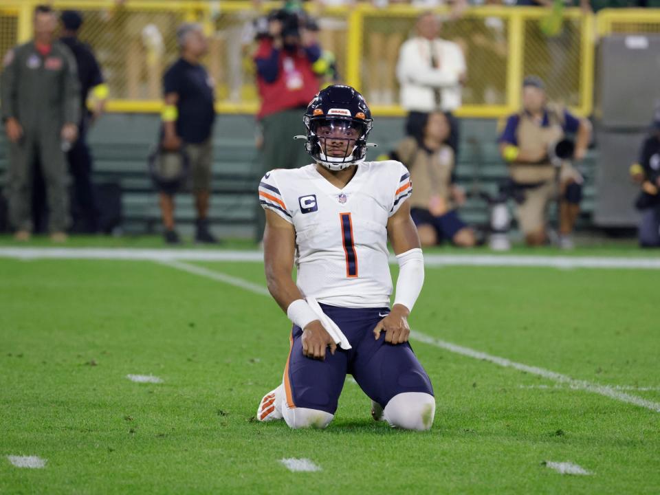 Justin Fields kneels during a game against the Green Bay Packers.