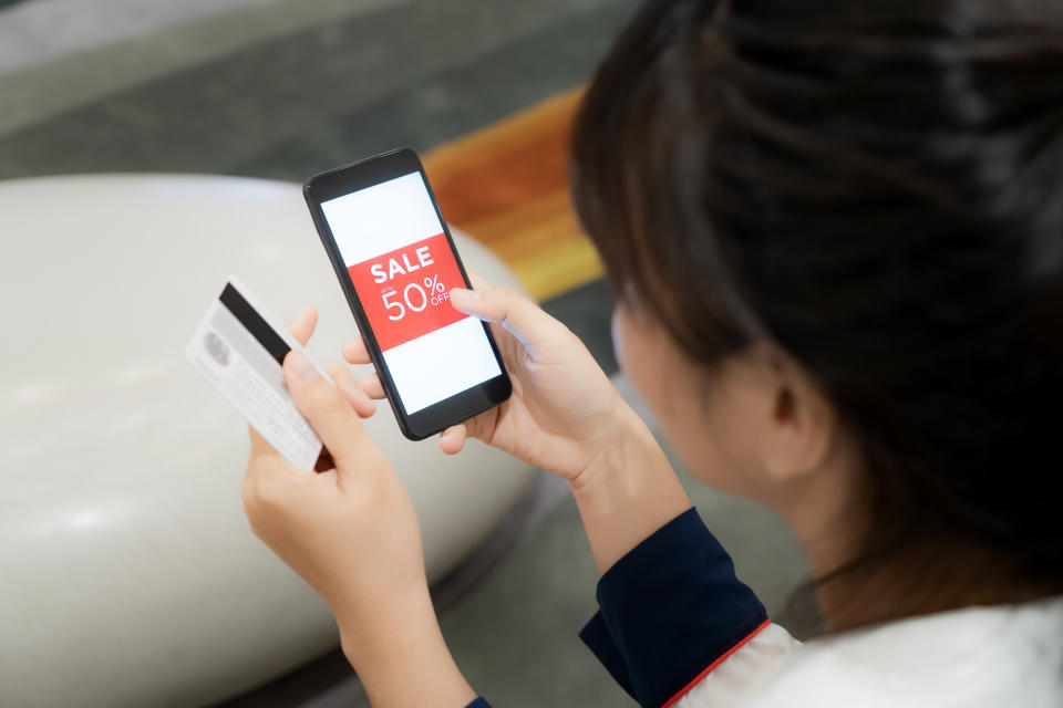 Woman holding smartphone and credit card  for e-commerce, business and technology concept