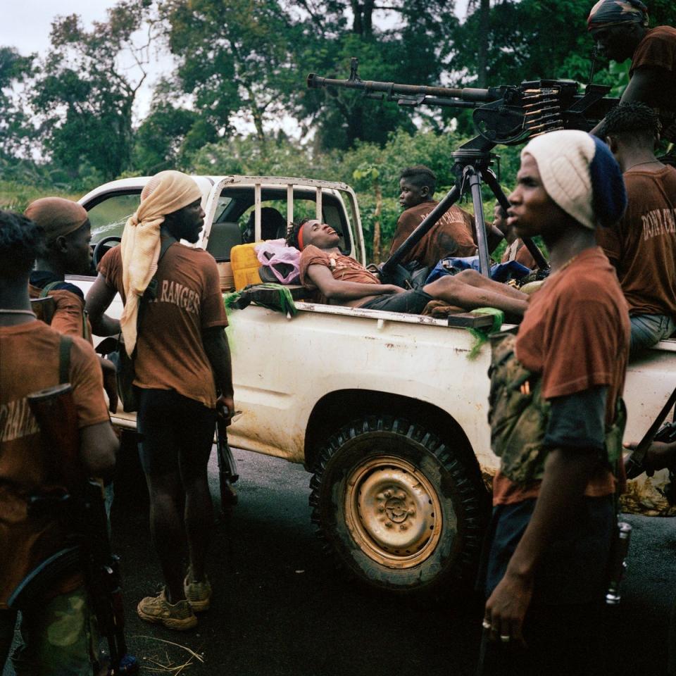 An ambush victim lies at the rear of a 'technical' battle during the attack on the capital by the rebel LURD force.  Po Rover, Liberia.  June 2003. (TIM A HETHERINGTON)