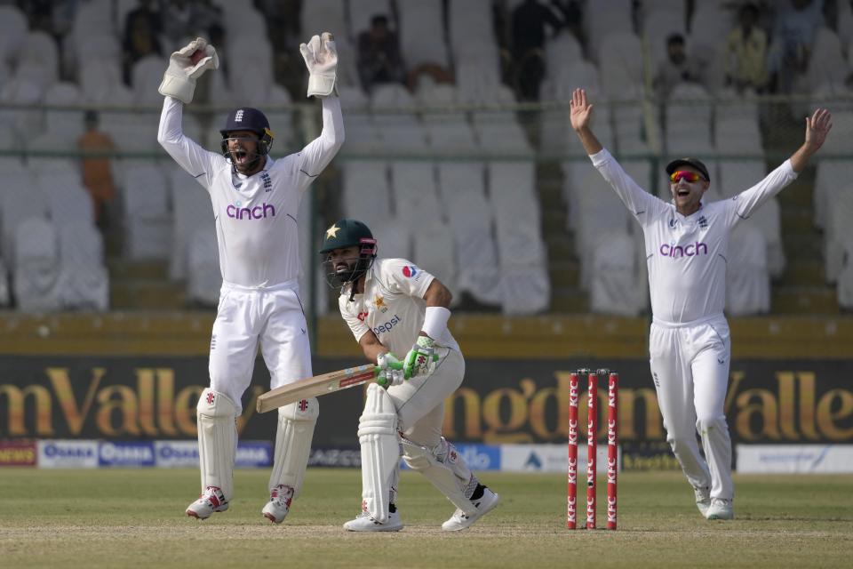 England's Ben Foakes, left, and Joe Root, right, appeals for caught behind out of Pakistan's Mohammad Rizwan, center, during the third day of third test cricket match between England and Pakistan, in Karachi, Pakistan, Monday, Dec. 19, 2022. (AP Photo/Fareed Khan)