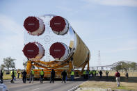 Security personnel walk with the core stage of NASA's Space Launch System rocket, that will be used for the Artemis 1 Mission, as it is moved to the Pegasus barge, at the NASA Michoud Assembly Facility where it was built, in New Orleans, Wednesday, Jan. 8, 2020. It will be transported to NASA's Stennis Space Center in Mississippi for its green run test. (AP Photo/Gerald Herbert)