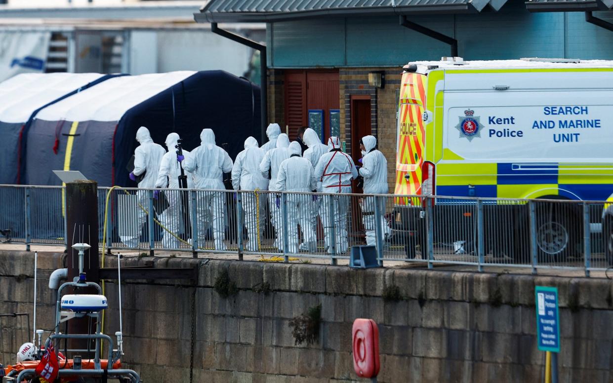 Police forensics officers wearing protective clothing investigate the disaster in the Channel in December 2022