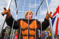 <p>A demonstrator in a gorilla suit and a mask in the likeness of President Donald Trump, stands in a cage in Parliament Square in London, U.K., on Friday, July 13, 2018. (Photo: Luke MacGregor/Bloomberg via Getty Images) </p>