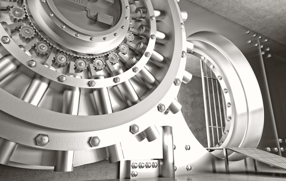 Silver-colored bank vault door, open to reveal inside.