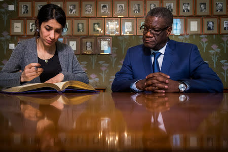 Dr. Denis Mukwege and Nadia Murad sign the Nobel guestbook at a news conference with the 2018 Nobel Laureates at the Nobel Institute in Oslo, Norway December 9, 2018. Heiko Junge/NTB Scanpix/via REUTERS