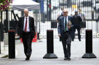 The government's chief medical officer Chris Whitty, left, and chief scientific adviser Patrick Vallance arrive in Downing Street, London, Monday Sept. 21, 2020. Britain’s top medical advisers have painted a grim picture of exponential growth in illness and death if nothing is done to control the second wave of coronavirus infections, laying the groundwork for the government to announce new restrictions later this week. (Yui Mok /PA via AP)