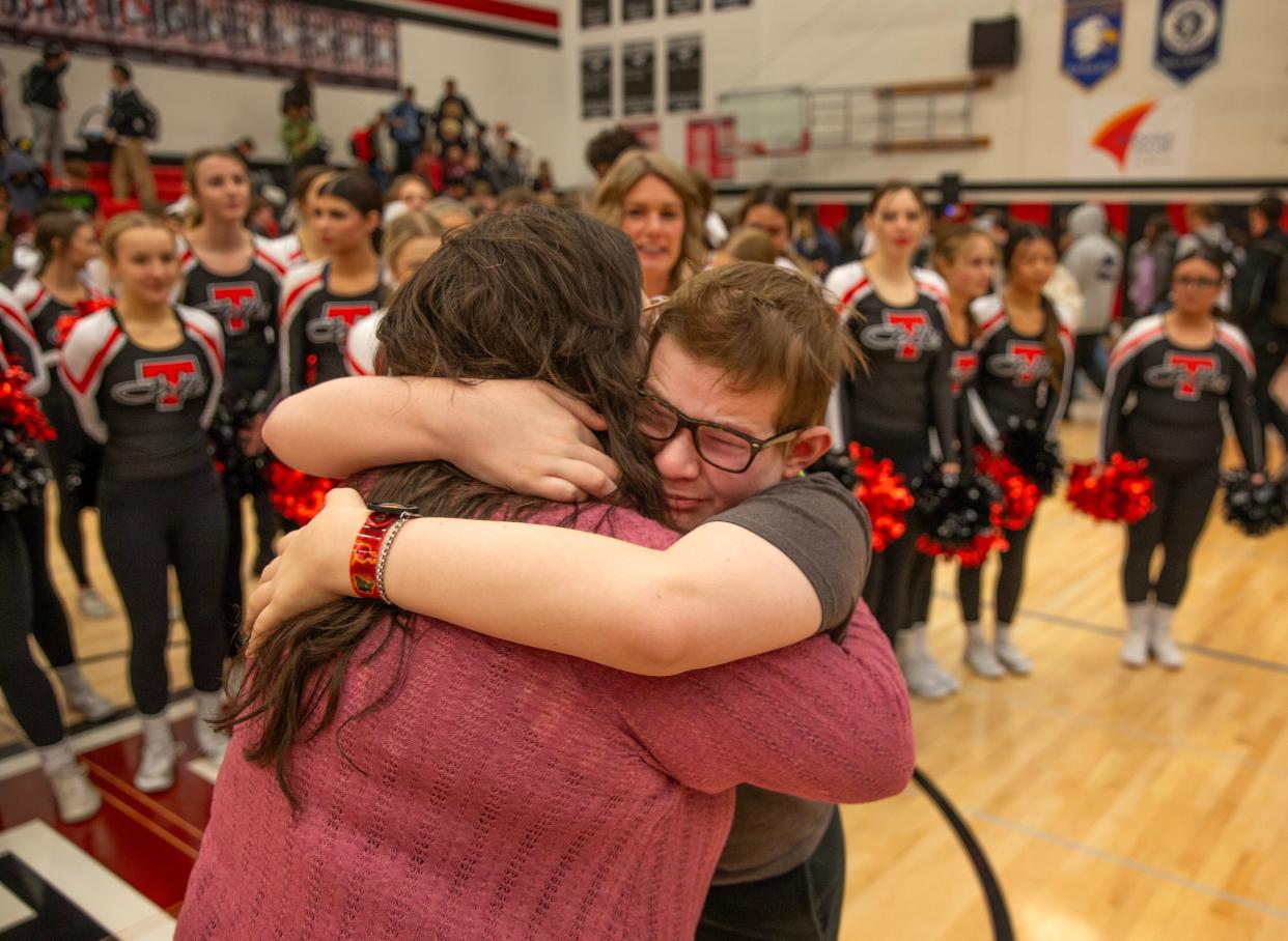 Sixteen-year-old Sam Lockard, right, gives his mother, Jennifer Clason, a hug during a school assembly at Thurston High School where he was introduced as the first “sparrow” for the new club.