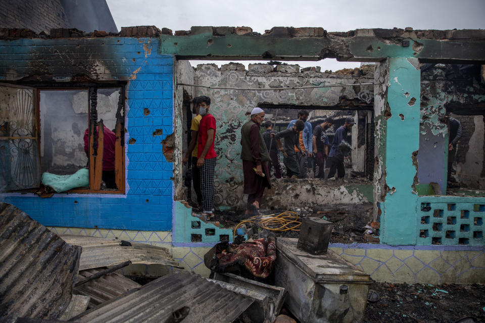 Kashmiri villagers stand inside a house destroyed in a gunfight in Pulwama, south of Srinagar, Indian controlled Kashmir, Wednesday, July 14, 2021. Three suspected rebels were killed in a gunfight in Indian-controlled Kashmir on Wednesday, officials said, as violence in the disputed region increased in recent weeks. Two residential houses were also destroyed. (AP Photo/ Dar Yasin)