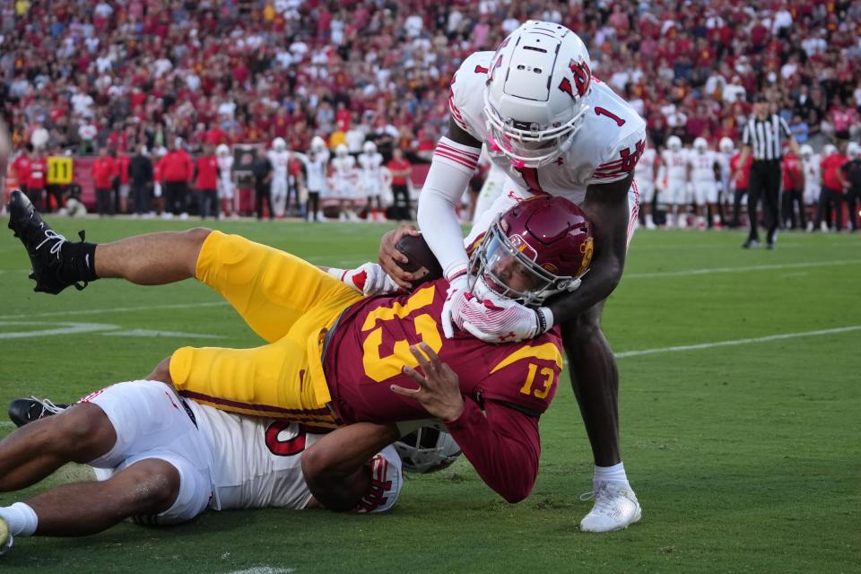 Southern California Trojans quarterback Caleb Williams (13) gets tackled by Utah Utes cornerback Miles Battle (1) and defensive end Jonah Elliss (83) in their game on Oct. 21.