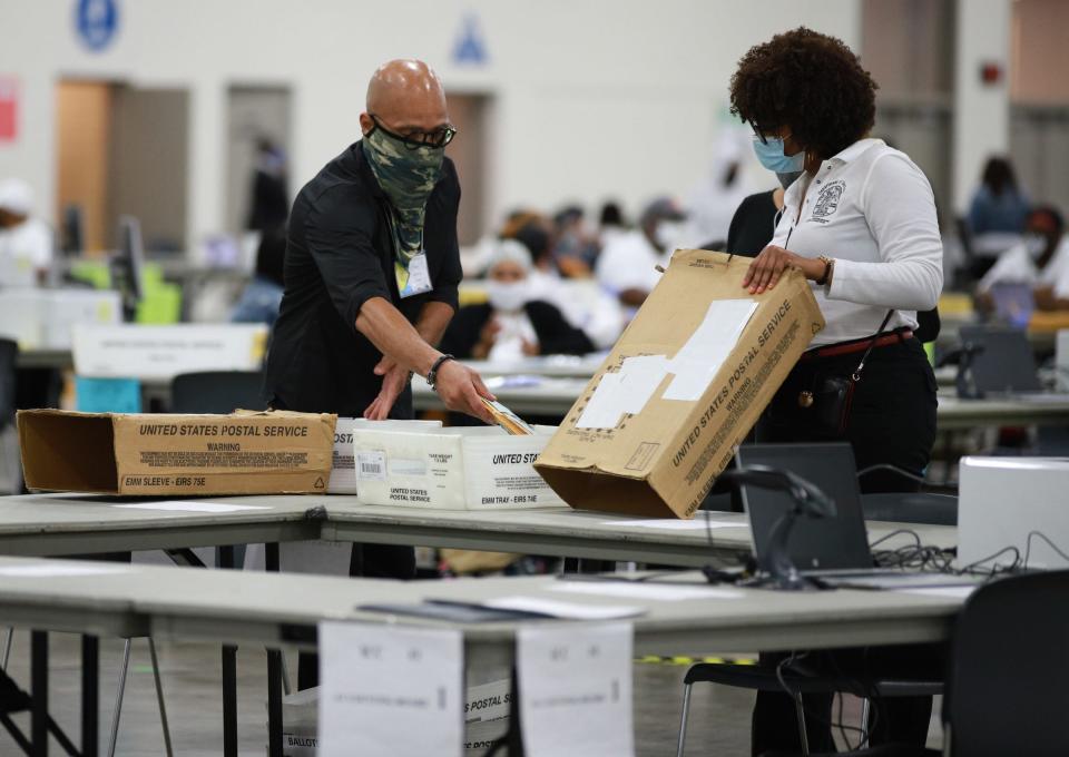 Election workers process absentee ballots at the counting board in Detroit on August 3, 2021. It takes longer to process absentee ballots compared to those cast in person. It could take up to 24 hours to complete the absentee ballot count for the upcoming Nov. 8 midterm.