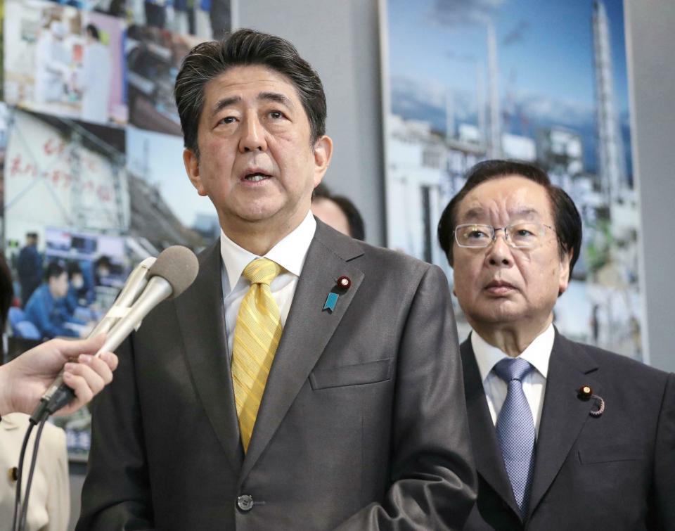 Japanese Prime Minister Shinzo Abe speaks to the media after Abe visited Fukushima Dai-ichi nuclear power plant in Okuma, Fukushima prefecture, Japan, Sunday, April 14, 2019. Prime Minister Abe inspected the reconstruction effort following the tsunami, quake and nuclear accident in 2011. (Kyodo News via AP)