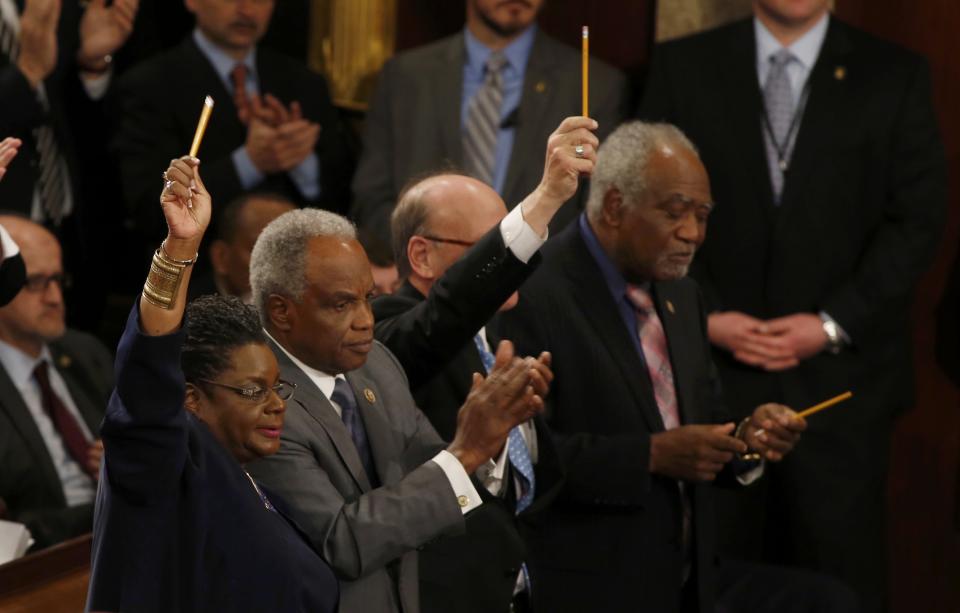 Members of the U.S. Congress hold up pencils in honor of the victims of the Paris attacks as President Barack Obama mentions the attack in his State of the Union address to a joint session of the U.S. Congress on Capitol Hill in Washington