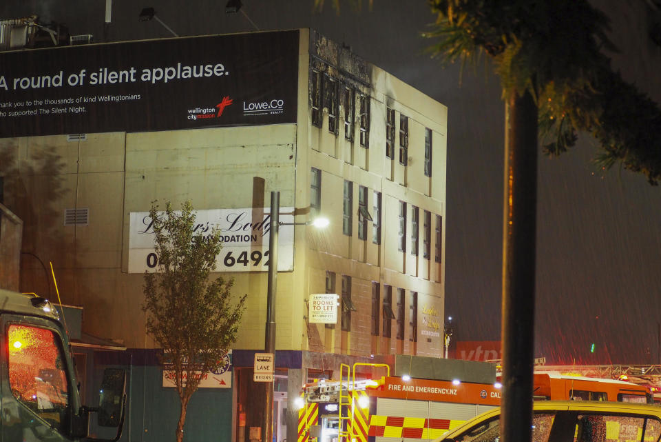 FILE - Fire fighters stand outside the Loafers Lodge hostel in central Wellington, New Zealand, on May 16, 2023. New Zealand police on Thursday, June 1, 2023 filed five murder charges against the man they say lit a deadly fire at a Wellington hostel two weeks ago. (Nick James/NZ Herald via AP, File)