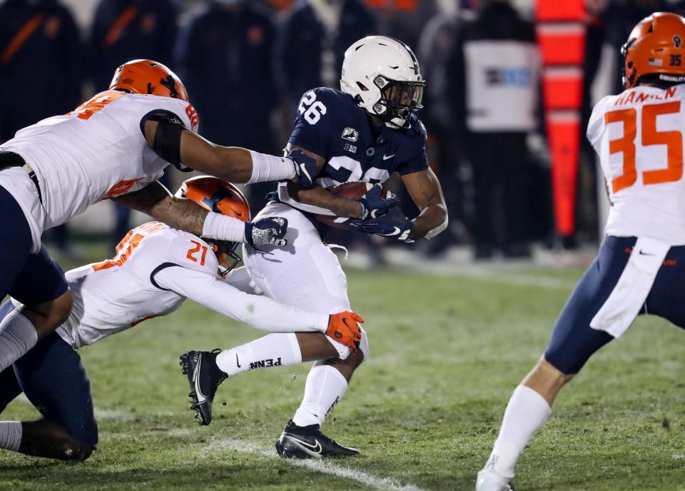 Dec 19, 2020; University Park, Pennsylvania, USA; Penn State Nittany Lions running back Caziah Holmes (26) breaks a tackle during the fourth quarter against the Illinois Fighting Illini at Beaver Stadium. Penn State defeated Illinois 56-21. Mandatory Credit: Matthew OHaren-USA TODAY Sports