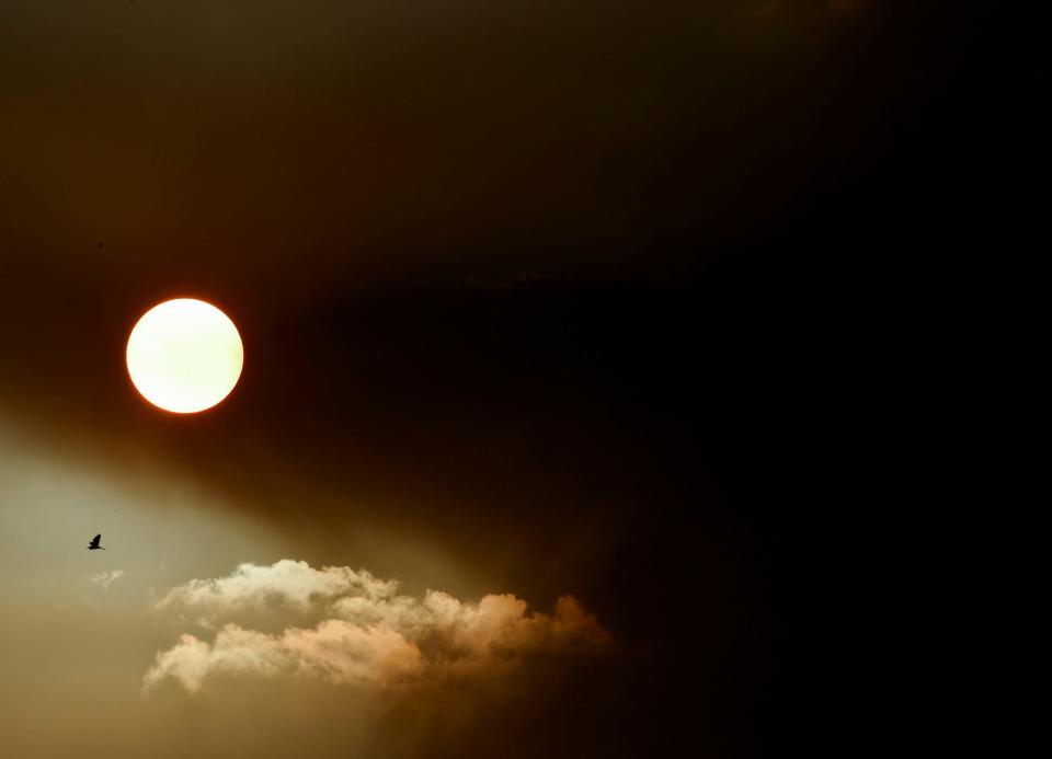 The sun sets as a wildfire burns Thursday evening March 23, 2023, in the John C. and Mariana Jones/Hungryland Wildlife and Environmental Area off Pratt Whitney Road in Martin County near Indiantown.