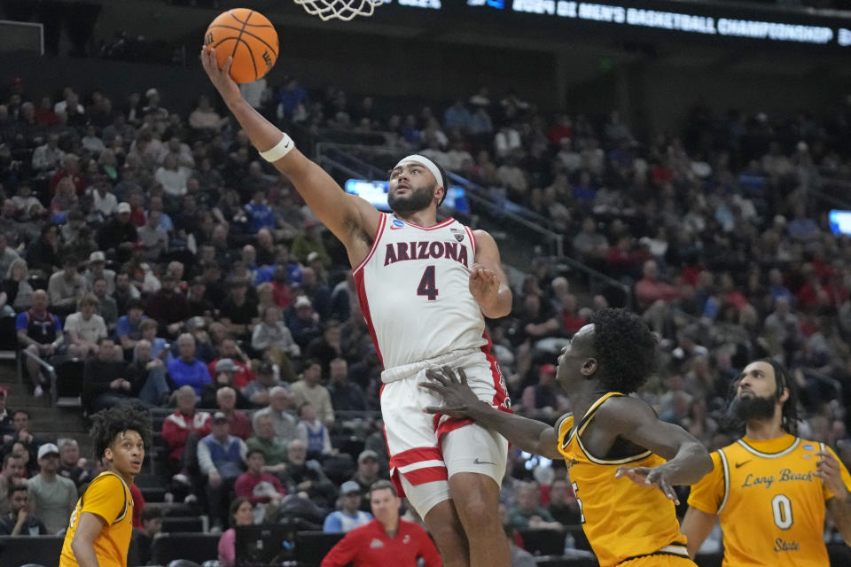 Long Beach State forward Aboubacar Traore, right, looks on as Arizona guard Kylan Boswell (4) goes to the basket during the second half of a first-round college basketball game in the NCAA Tournament in Salt Lake City, Thursday, March 21, 2024. (AP Photo/Rick Bowmer)