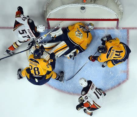 Apr 21, 2016; Nashville, TN, USA; Nashville Predators goalie Pekka Rinne (35) lays on the puck as Anaheim Ducks left winger David Perron (57) tries to score during the second period in game four of the first round of the 2016 Stanley Cup Playoffs at Bridgestone Arena. Christopher Hanewinckel-USA TODAY Sports