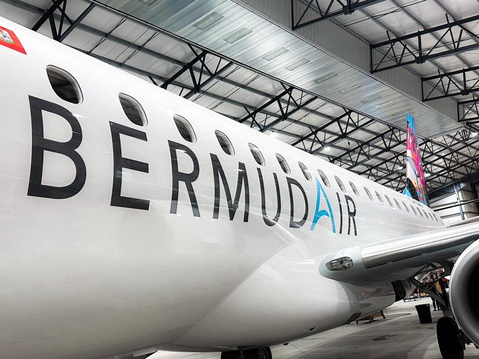 A close up of the BermudAir logo along the side of the E175's white fuselage.