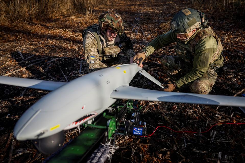 Two Ukrainian soldiers check a Shark drone before launching it at Russian positions in Kharkiv, Ukraine (REUTERS)