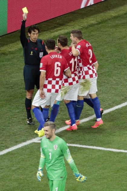 Croatia's Dejan Lovren (6) is booked by referee Yuichi Nishimura. (AP)