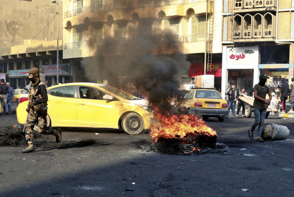 Protesters set fires during ongoing protests in Baghdad, Iraq, Sunday, Dec. 1, 2019. Iraq's parliament approved the resignation of Prime Minister Adel Abdul-Mahdi on Sunday, amid ongoing violence and anti-government demonstrations in the capital. (AP Photo/Hadi Mizban)