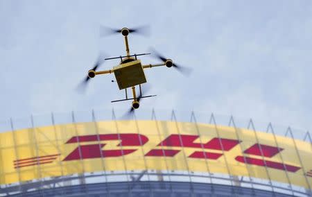 A prototype "parcelcopter" of German postal and logistics group Deutsche Post DHL flies in front of the company's headquarters in Bonn December 9, 2013. REUTERS/Wolfgang Rattay