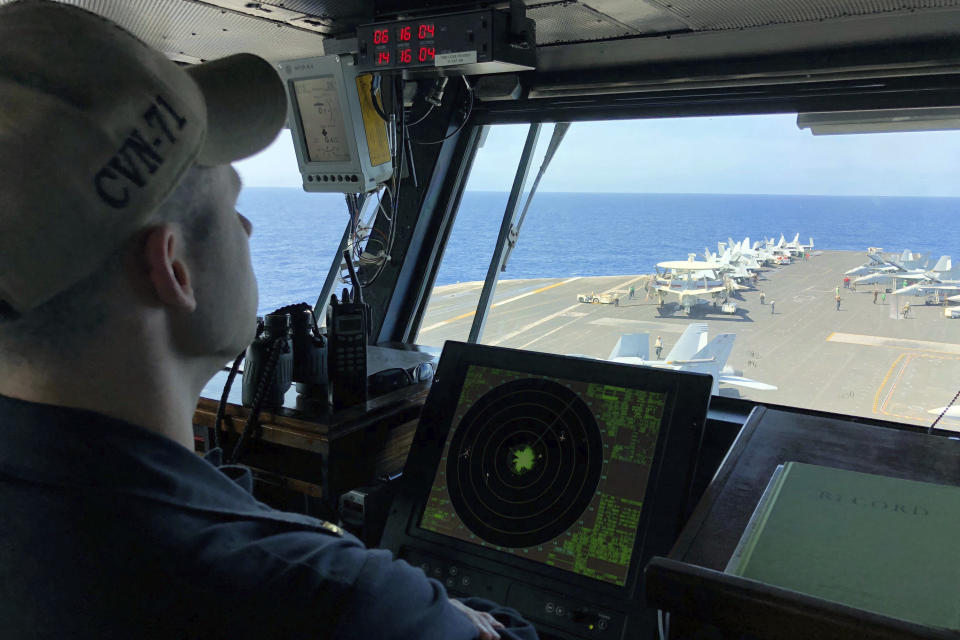 FILE - In this April 10, 2018, file photo, a U.S. Navy crewman monitors on the deck of the U.S. aircraft carrier Theodore Roosevelt in international waters off South China Sea. The USS Theodore Roosevelt made the second-ever visit by a U.S. aircraft carrier strike group to Vietnam to mark 25 years of diplomatic relations and growing security ties between the former Cold War antagonists amid China's aggressive moves in the South China Sea. (AP Photo/Jim Gomez, File)