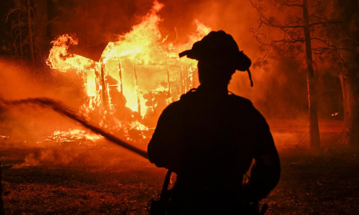 <span>Smoke and flames rise from the forest as crews try to extinguish a wildfire in Chico, California, on 25 July 2024.</span><span>Photograph: Anadolu/Getty Images</span>