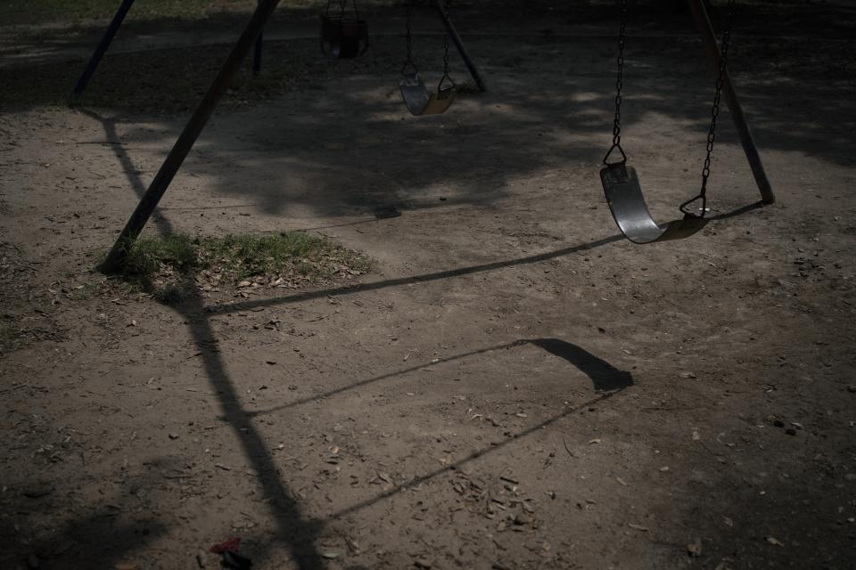 Empty swings hang still at Uvalde Memorial Park on Friday, May 27, 2022, in Uvalde, Texas. The places where kids would have played are closed or quiet after after a deadly school shooting took the lives of 19 children and two teachers. (AP Photo/Wong Maye-E)