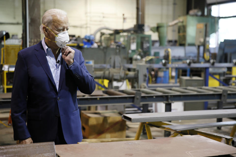 FILE - In this July 9, 2020, file photo Democratic presidential candidate, former Vice President Joe Biden adjusts his mask during a tour of McGregor Industries, a metal fabricating facility in Dunmore, Pa. Biden wants to juice U.S. manufacturing by directing $400 billion of federal government purchases to domestic firms (part of that for buying pandemic supplies) over a four-year term. Biden says the new domestic spending must come before he enters into any new international trade deals. (AP Photo/Matt Slocum, File)