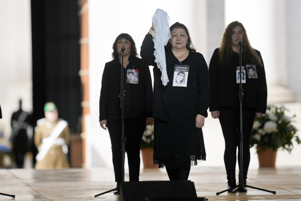 Gaby Rivera, al centro, presidenta de la Asociación de Familiares de Detenidos Desaparecidos, baila la cueca durante una ceremonia en el palacio presidencial de La Moneda para conmemorar el 50 aniversario del golpe militar de 1973 que derrocó al gobierno del fallecido presidente Salvador Allende en Santiago, Chile, lunes 11 de septiembre de 2023. (AP Foto/Esteban Félix)