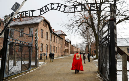 Far right activists walk past the "Arbeit Macht Frei" gate at the former Nazi German concentration and extermination camp Auschwitz, to attend the ceremonies marking the 74th anniversary of the liberation of the camp and International Holocaust Victims Remembrance Day, in Oswiecim, Poland, January 27, 2019. REUTERS/Kacper Pempel