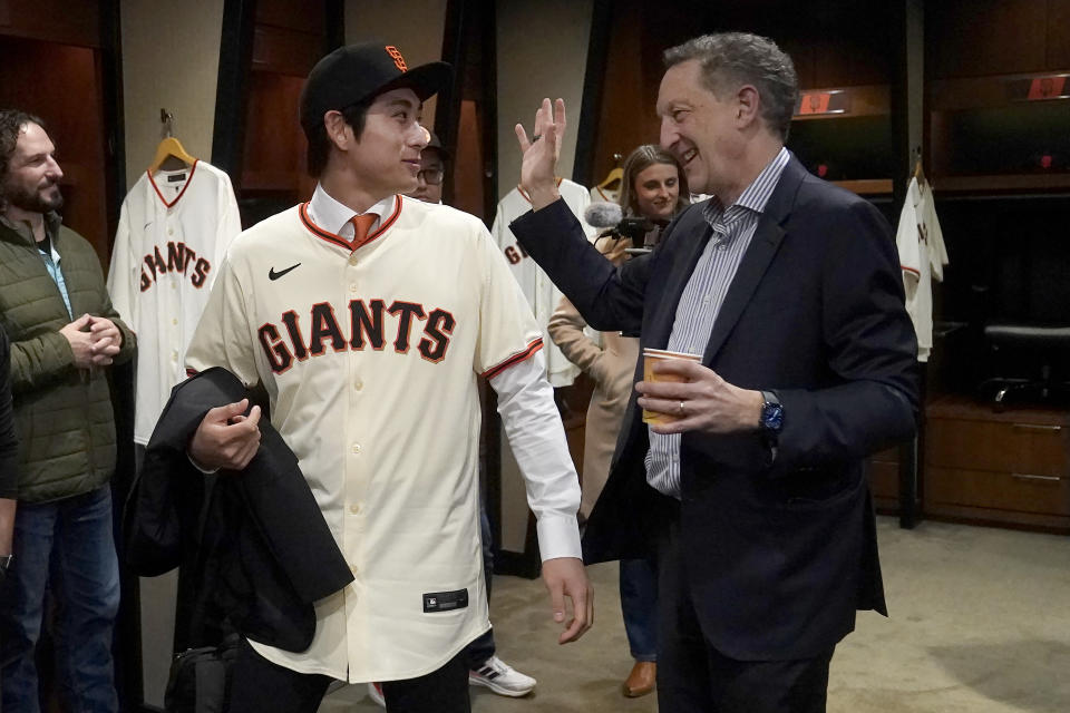 San Francisco Giants' Jung Hoo Lee, front left, walks with team CEO and President Larry Baer, right, after a baseball news conference in San Francisco, Friday, Dec. 15, 2023. (AP Photo/Jeff Chiu)