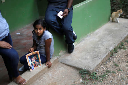 Marcela, 9, daughter of Douglas Almendarez, 37, a deportee from the U.S. who was separated from his son Eduardo Almendarez, 11, at the Rio Grande entry point under the Trump administration's hardline immigration policy, holds a photo of her brother Eduardo Almendarez, 11, in La Union, in Olancho state Honduras July 14, 2018. Picture taken July 14, 2018. REUTERS/Edgard Garrido