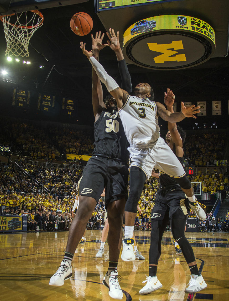 FILE - In this Dec. 1, 2018, file photo, Michigan guard Zavier Simpson (3) goes to the basket defended by Purdue forward Trevion Williams (50) in the second half of an NCAA college basketball game, in Ann Arbor, Mich. Simpson was named to the AP All-Big Ten Conference team, Tuesday, March 12, 2019. (AP Photo/Tony Ding, File)