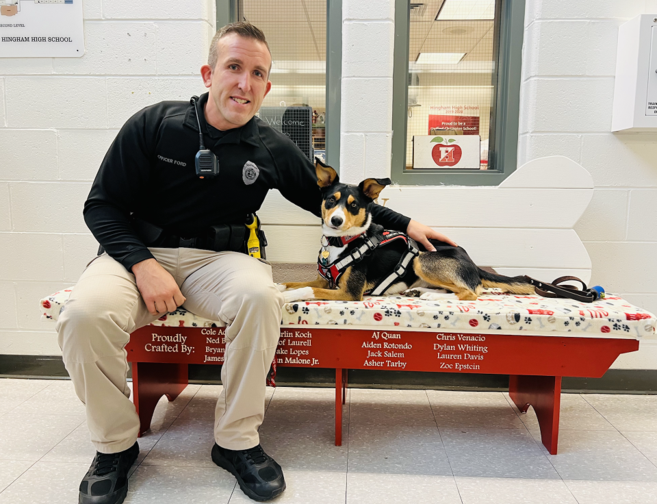 Hingham Police Department School Resource Officer Thomas Ford works with his comfort dog, Opry, at Hingham High School.