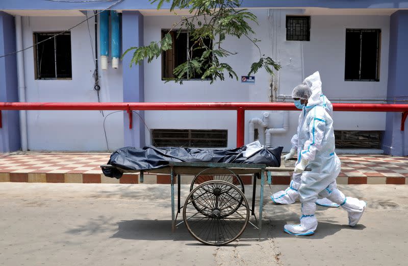 Healthcare workers transfer the body of a person who died from the coronavirus disease (COVID-19), inside a hospital premises in Kolkata