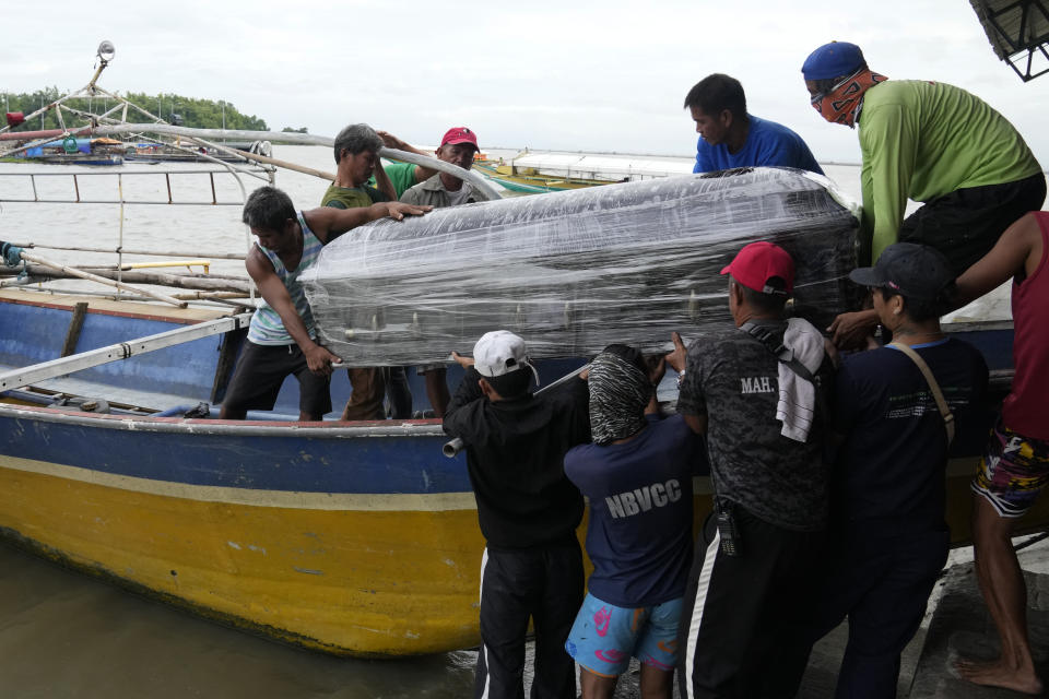 A coffin of one of the victims of a passenger boat that capsized is carried on a boat at a port in Binangonan, Rizal province, Philippines on Friday, July 28, 2023. A small Philippine ferry turned upside down when passengers suddenly crowded to one side in panic as fierce winds pummeled the wooden vessel, leaving multiple people dead while others were rescued, officials said Friday. (AP Photo/Aaron Favila)