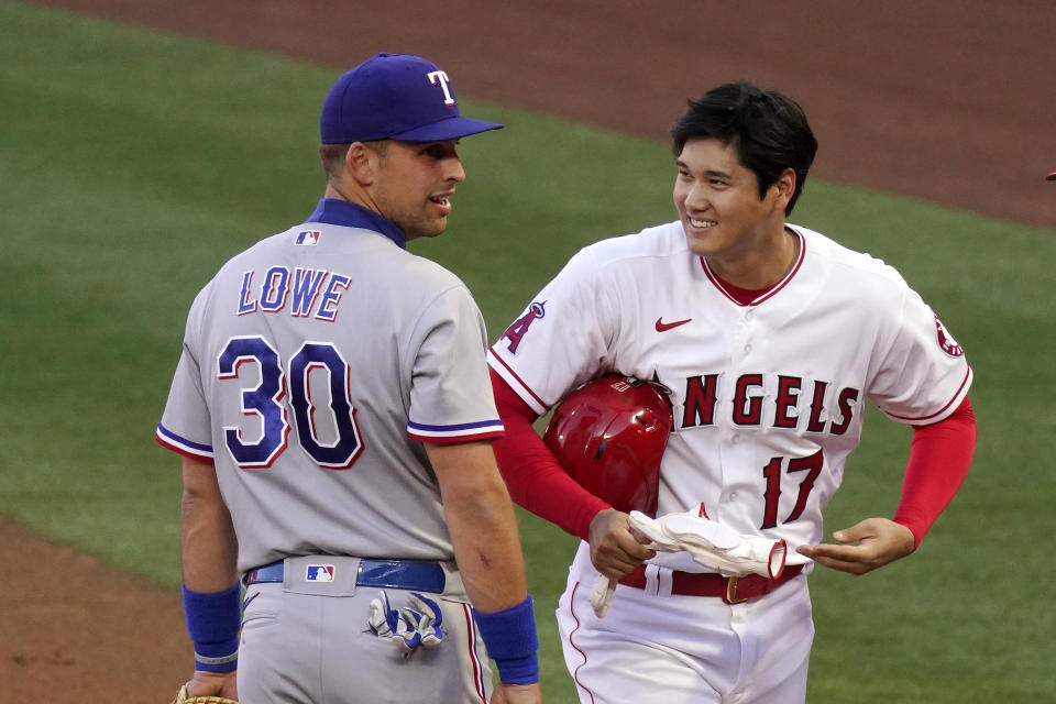 Los Angeles Angels' Shohei Ohtani, right, talks with Texas Rangers first baseman Nate Lowe after being thrown out at first during the first inning of a baseball game Monday, April 19, 2021, in Anaheim, Calif. (AP Photo/Mark J. Terrill)