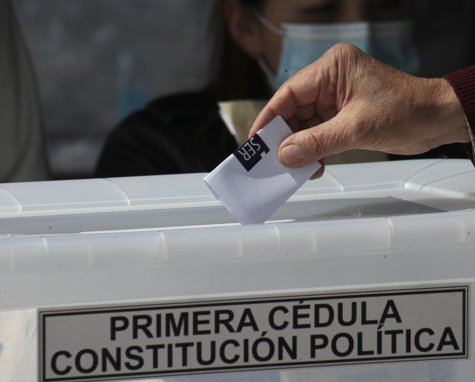 FILE - In this Oct. 25, 2020 file photo, a person votes at a polling station during a referendum to decide whether the country should replace its 40-year-old constitution, in Santiago, Chile. The referendum passed, and Chileans will next elect an assembly to write fresh governing principles and put them to a national vote in 2022, with the goal of a more inclusive country and the erasure of a much-amended relic of military rule, the 1980 constitution. (AP Photo/Esteban Felix, File)