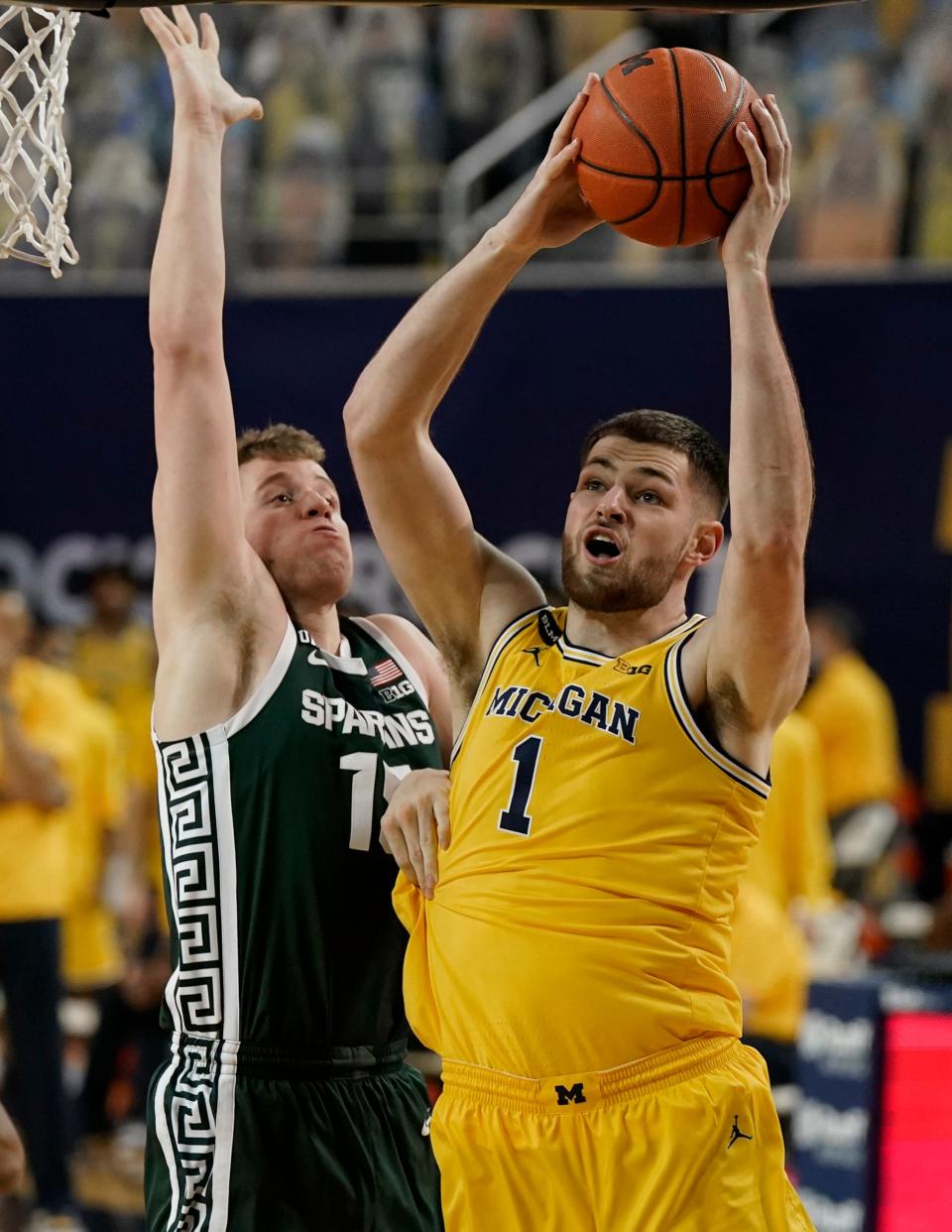 Hunter Dickinson is defended by MSU's Thomas Kithier during the first half Thursday at Crisler Center.