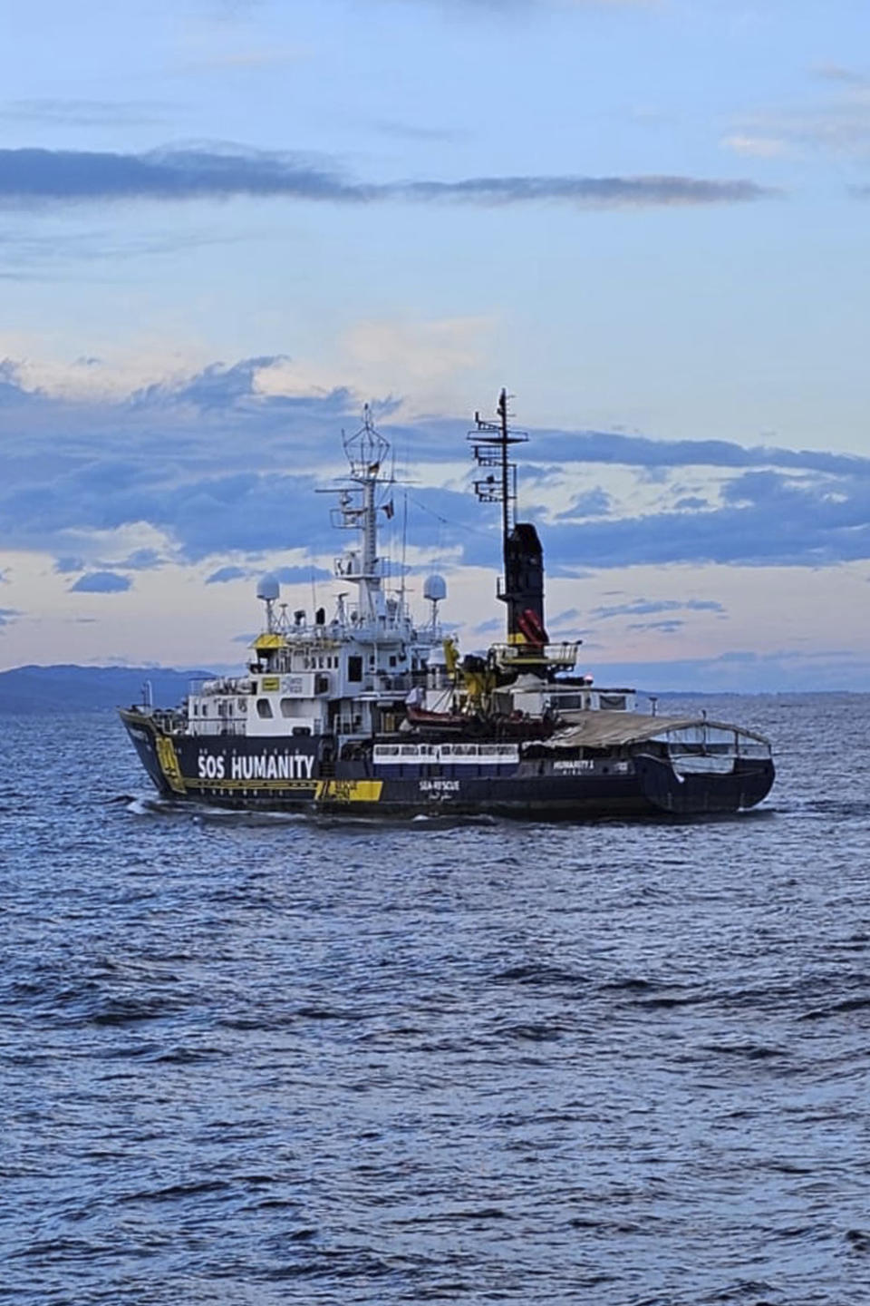 The SOS Humanity 1 humanitarian ship carrying some 77 migrants approaches the Italian southern port town of Crotone, Monday, March 4, 2023. German charity SOS Humanity said the Libyan coast guard used violence and fired live bullets as its crew rescued migrants in the Mediterranean Sea on Saturday. The charity said that several migrants aboard three unseaworthy boats had to jump into the water. It said that it rescued 77 people, but that others were forced aboard a coast guard vessel. Some family members were separated and at least one migrant drowned. (Antonino D'Urso/LaPresse via AP )