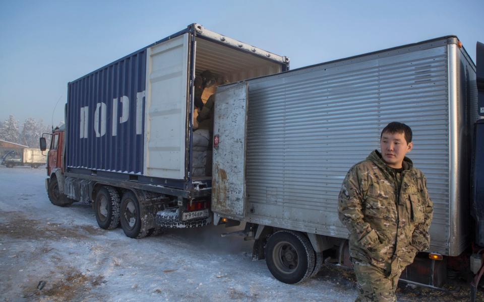 Goods are moved into a smaller truck to get around weight limits on the ice roads - Maria Turchenkova 