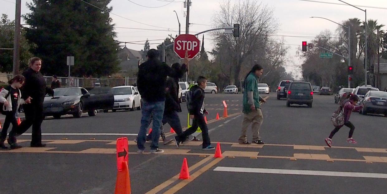 A student, right, runs across the crosswalk at the end of classes at El Dorado School in Stockton. Pedestrian safety improvements will be coming near six Stockton schools by summer 2023.